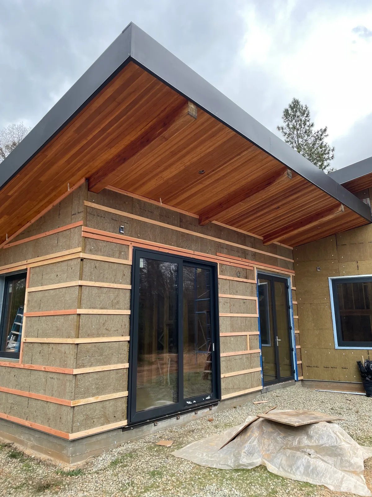 Mineral wool exterior insulation with wood furring strips beneath a fir soffit