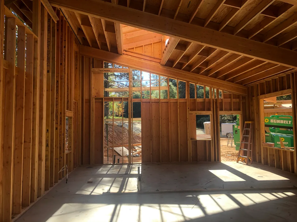 Framed great room with clerestory openings and sunlight across the slab
