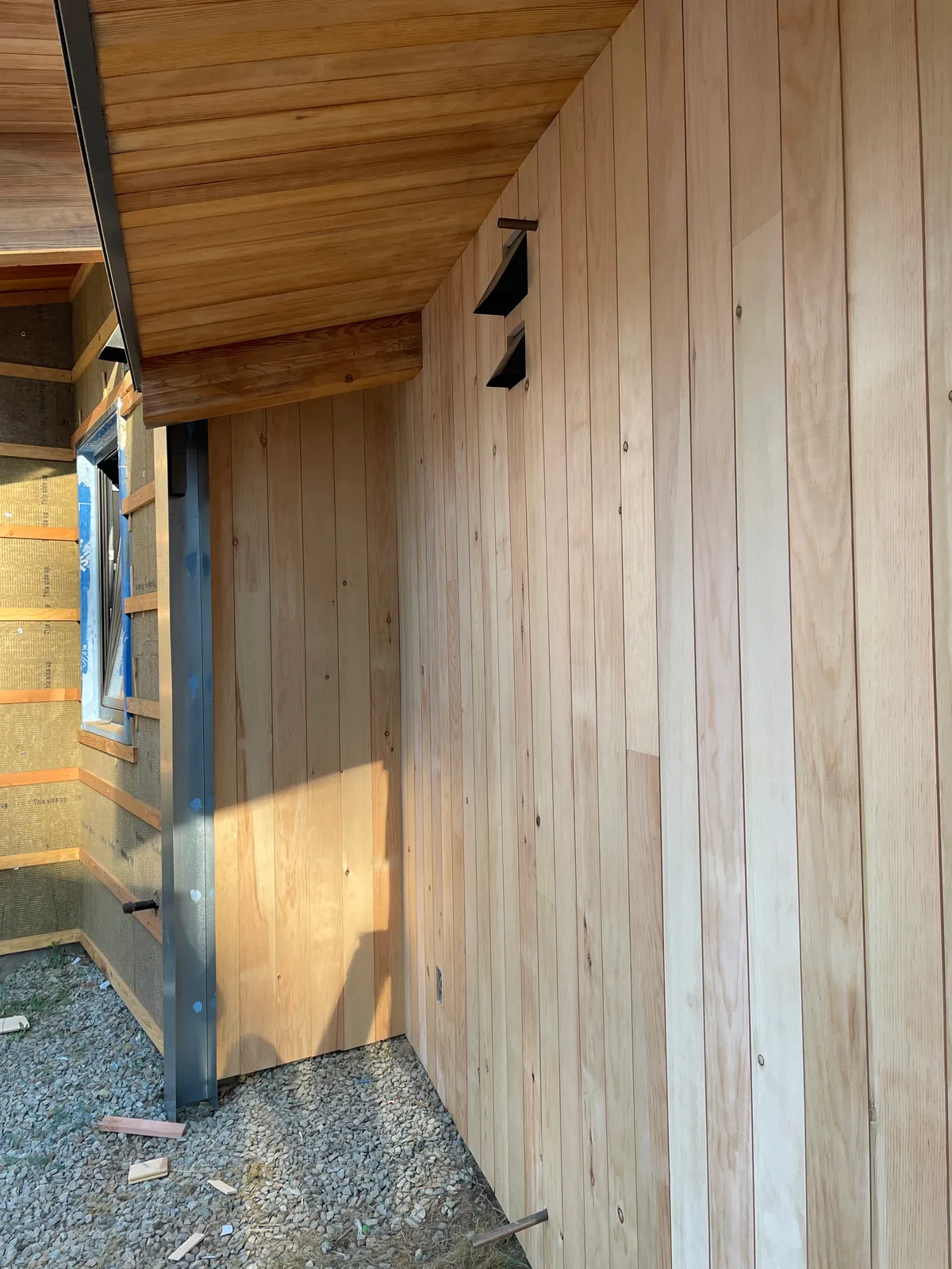 Reclaimed sugar pine siding being installed under a covered porch